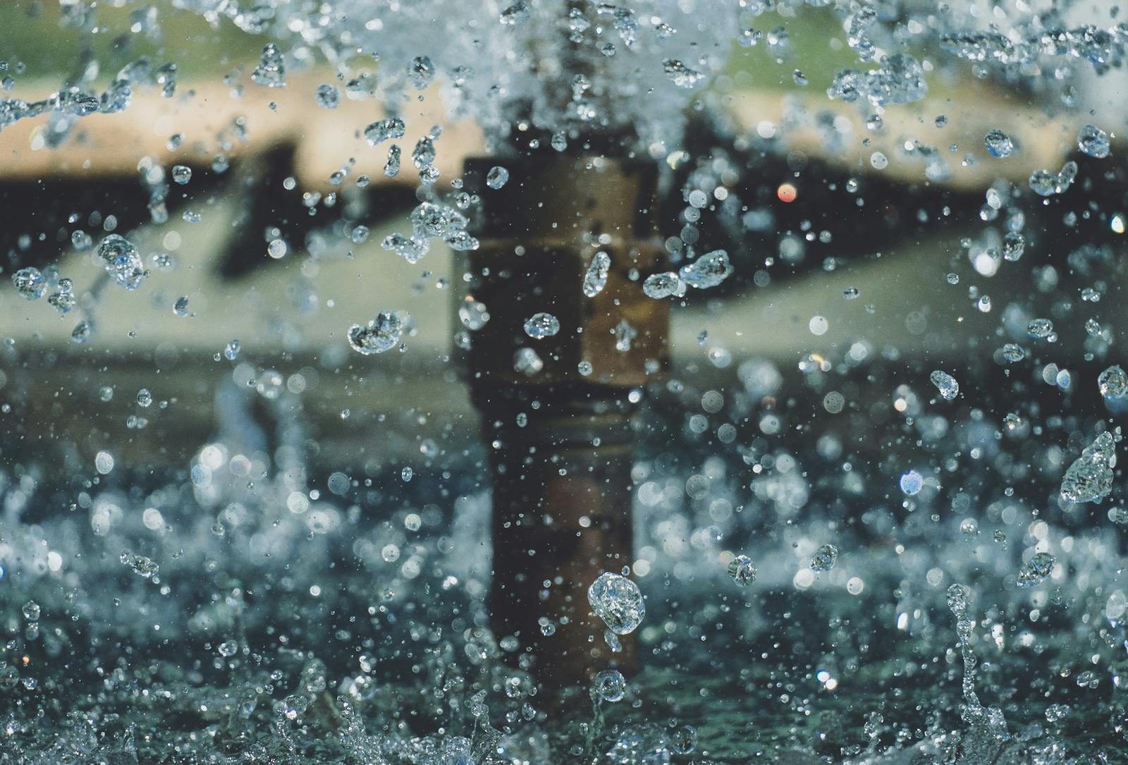 Close-up of water droplets mid-air from a fountain, capturing motion and clarity in an outdoor setting.